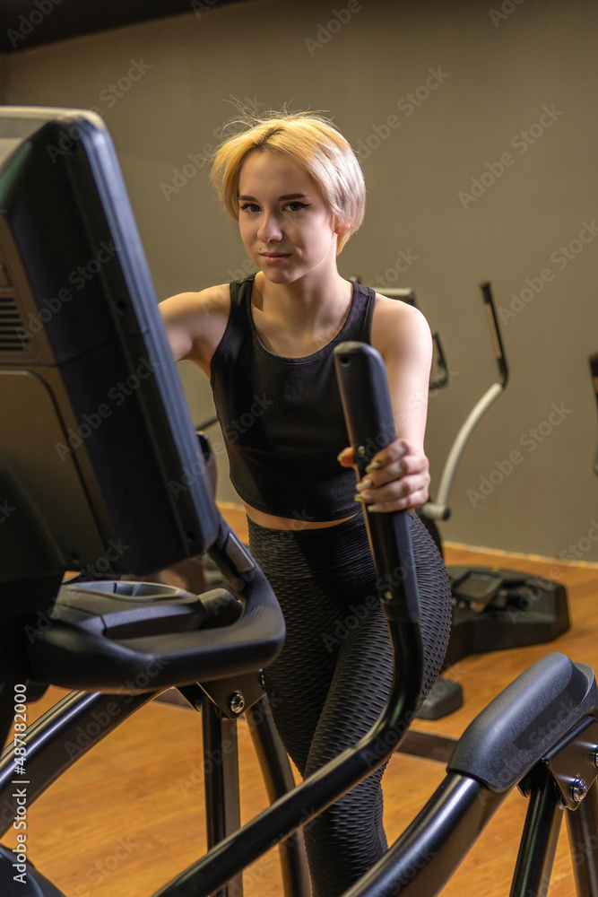 Elliptical trainer young training person, for female gym in running instructor sportswear, room elliptical. Cardio lifestyle living, trainer Elliptical trainer young training person, for female gym in running instructor sportswear, room elliptical. Cardio lifestyle living, trainer
