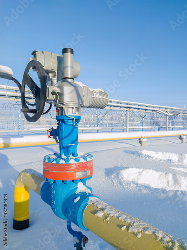Gate valve with handwheel and electric drive. Covering the section of the condensate pipeline. The concept of oil, gas industry. Industrial site background.