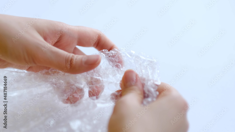 Fototapeta premium ASMR, woman presses plastic bubble wrap as a stress relief. Popping bubble wrap