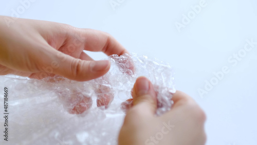 ASMR, woman presses plastic bubble wrap as a stress relief. Popping bubble wrap