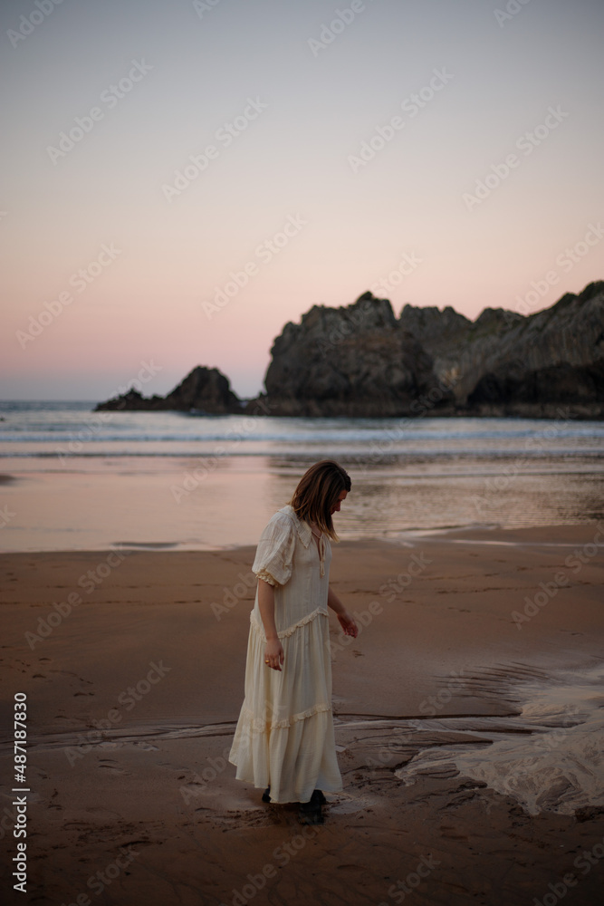 young girl enjoying the sunset on the beach in a long dress young girl enjoying the sunset on the beach in a long dress