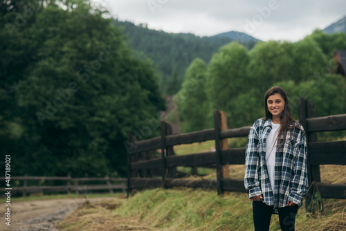 A young attractive Caucasian female sitting on a fence © teksomolika