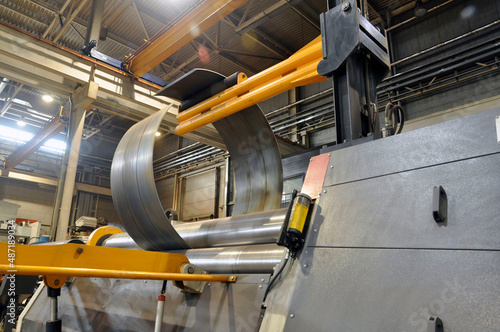Sheet metal bending on an industrial roller machine.