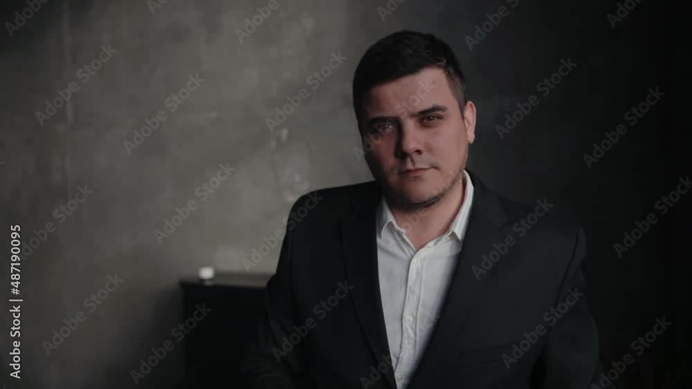 Man in black suit is holding clapperboard or clipboard in hands. Guy is directing and filming some cinema movie. Man in black suit is holding clapperboard or clipboard in hands. Guy is directing and filming some cinema movie.