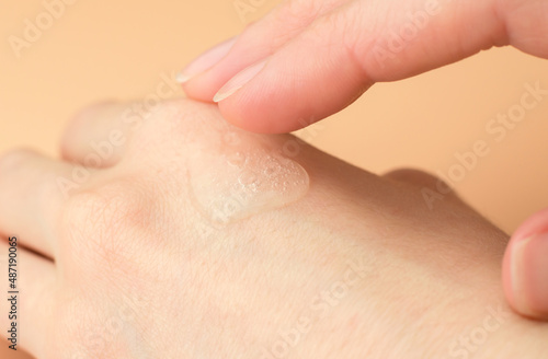Transparent gel on a female hand. Woman applying moisturizing gel on her wrist