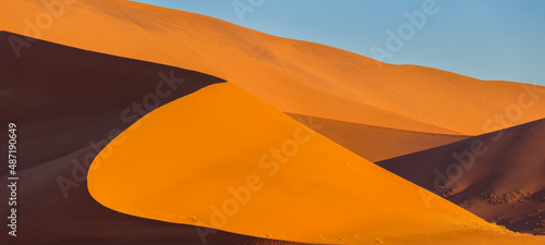 Sunset over sand dunes in the Namib desert in the vicinity of Sesriem, Namibia; abstract patterns of light and shadow