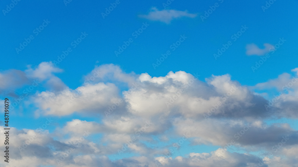 Picturesque blue sky with white fluffy clouds in sunny weather