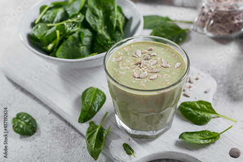 Glass of homemade healthy green smoothie with fresh baby spinach