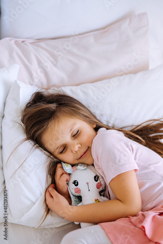 little girl with toy sleeping at home