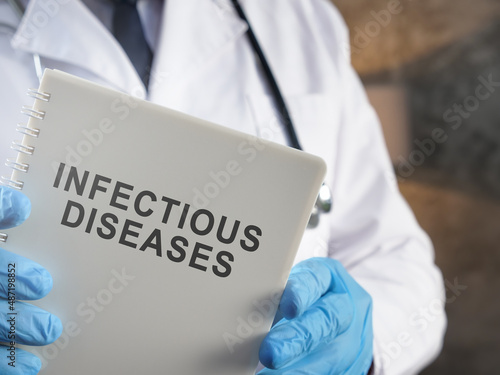 A Doctor holds book about infectious diseases. photo