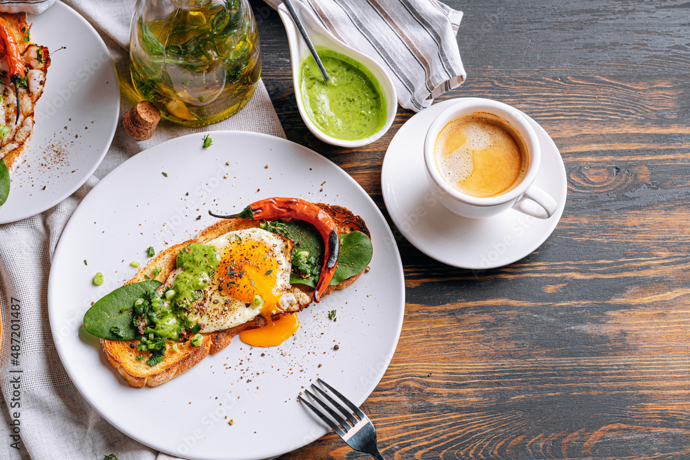 hearty and high-calorie breakfast. delicious and mouth-watering bruschetta with fried eggs and herbs for breakfast with a cup of aromatic coffee.