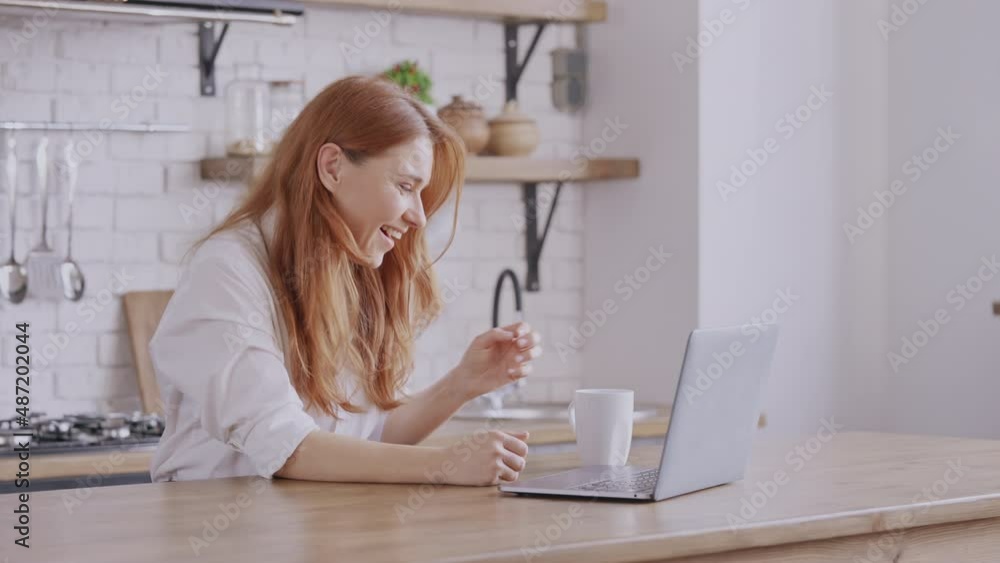 adult woman with long red hair talking with friend using webcam on laptop friendly smiling waving hand adult woman with long red hair talking with friend using webcam on laptop friendly smiling waving hand
