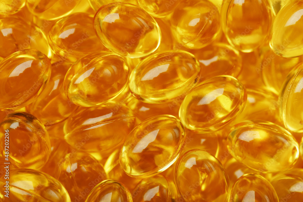 Golden capsules of Vitamin Omega 3 Fish Oil close-up Golden capsules of Vitamin Omega 3 Fish Oil close-up