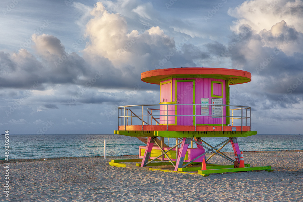 Colorful Art Deco 10th street Lifeguard Station on Miami Beach at Sunrise with Dramatic Clouds and Tranquil Ocean Waves Colorful Art Deco 10th street Lifeguard Station on Miami Beach at Sunrise with Dramatic Clouds and Tranquil Ocean Waves