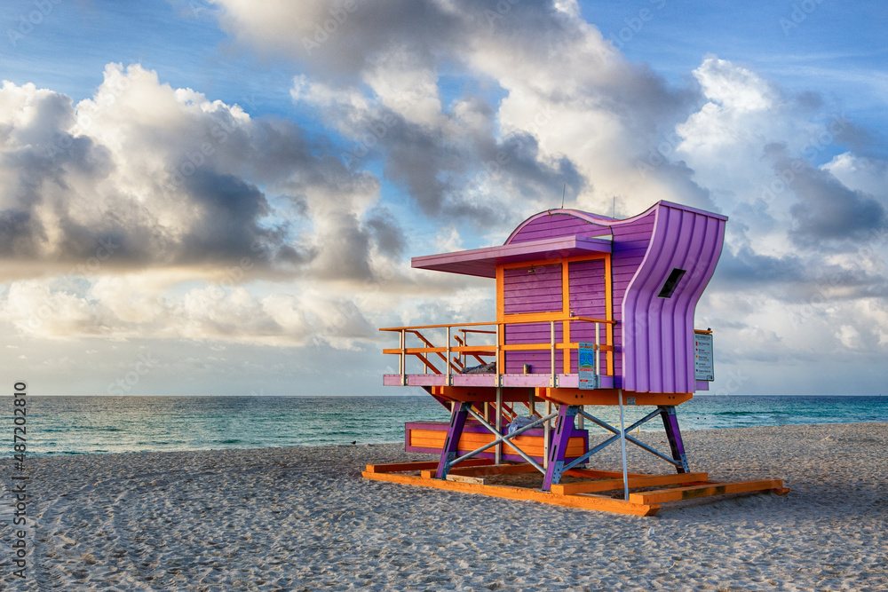 Fototapeta premium Colorful 12th street Art Deco Lifeguard Station at Sunrise on Miami Beach with Clouds and Ocean Waves in the Backdrop