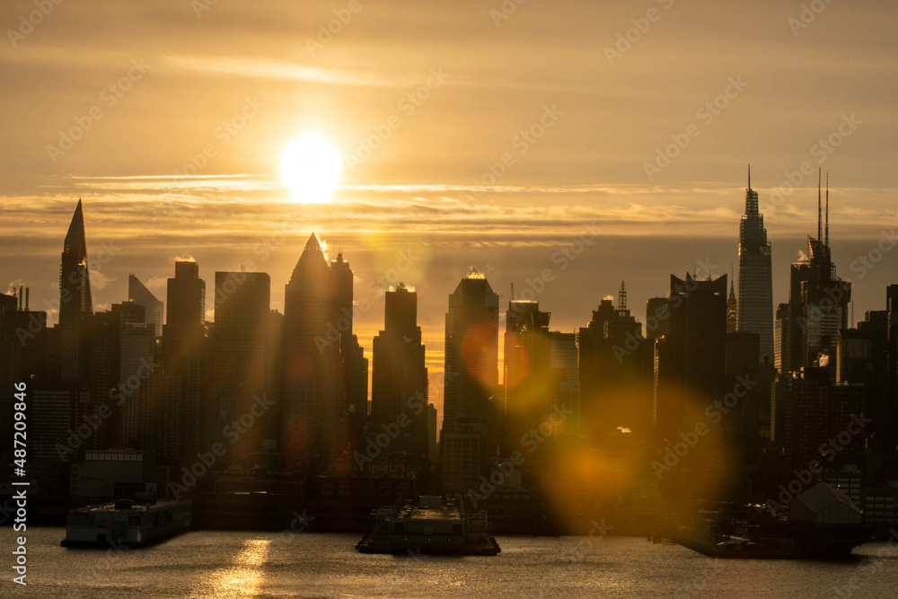 Obraz premium Stunning morning sunrise over Manhattan skyline in silhouette and vivid sky-clouds.