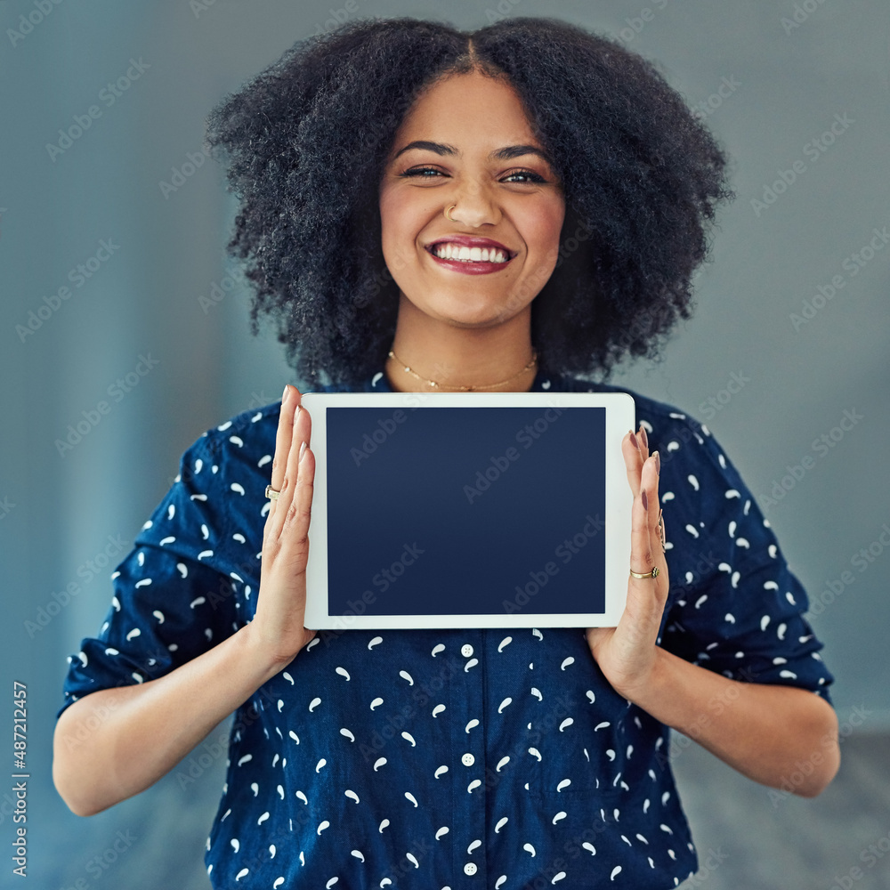 This is the app for you. Studio shot of a young woman holding up a digital tablet with a blank screen against a gray background. This is the app for you. Studio shot of a young woman holding up a digital tablet with a blank screen against a gray background.