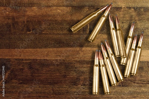 gun bullets on wooden surface background photo