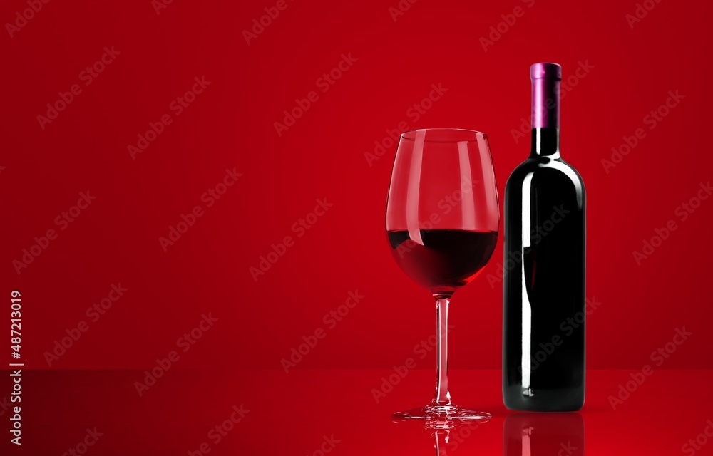 Red wine glass over colored background on the desk Red wine glass over colored background on the desk