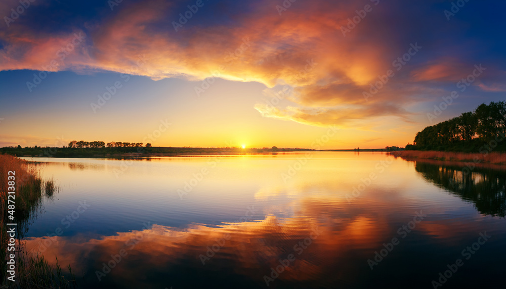 Fantastic view of the sundown over water surface on a cozy lake.