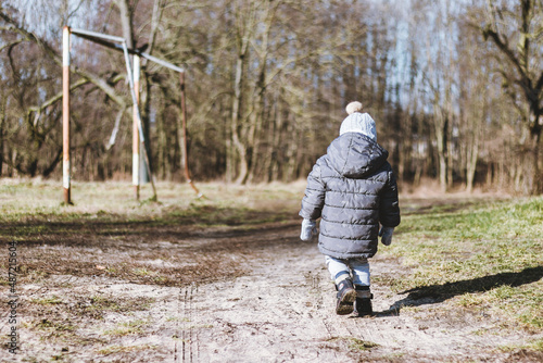 Samotny chłopiec spacerujący w parku.