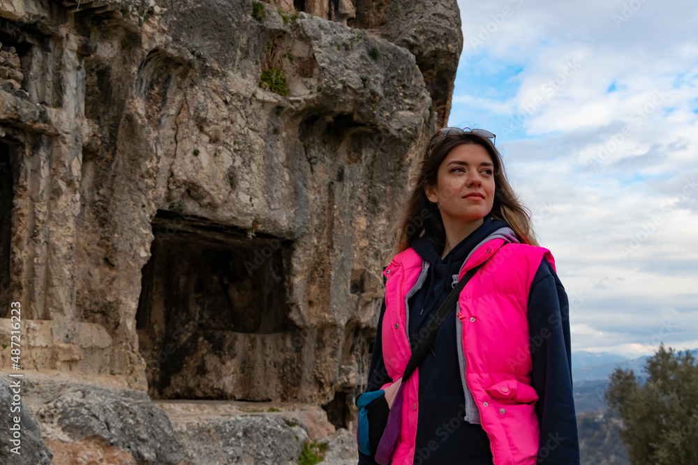 Tlos ancient city from Fethiye, Turkey. Young woman is standing on ruins and looking up. Tlos ancient city from Fethiye, Turkey. Young woman is standing on ruins and looking up.