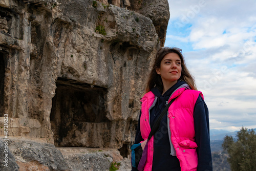 Tlos ancient city from Fethiye, Turkey. Young woman is standing on ruins and looking up. 