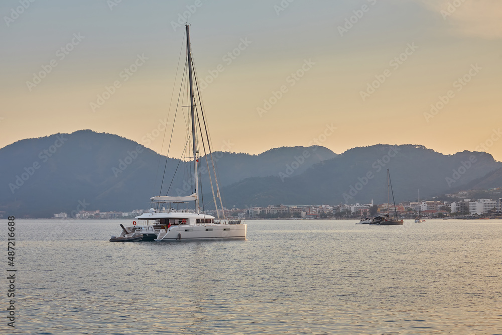 mountain and lonely motor boat reflected sunrise in a calm sea, Marmaris