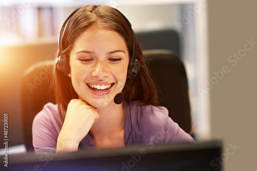 Making a log of all the calls she receives. Cropped shot of a young businesswoman wearing a headset at her desk.