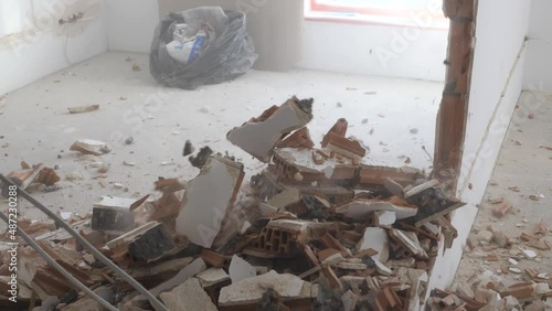 Man hitting a brick wall with a hammer, wall demolition