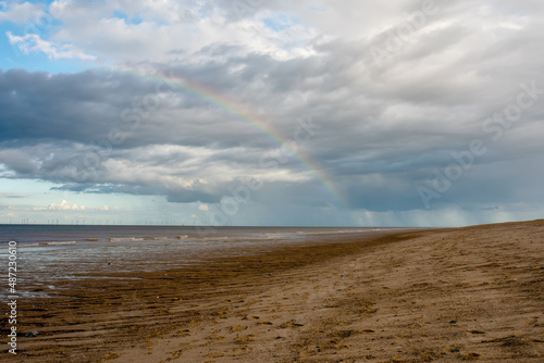 Sand beach, sea and cloudy blue sky in England in sunny day