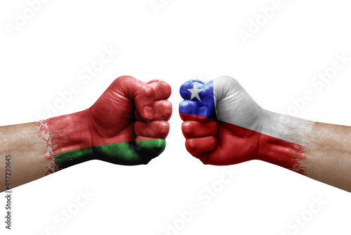 Two hands punch to each others on white background. Country flags painted fists, conflict crisis concept between belarus and chile