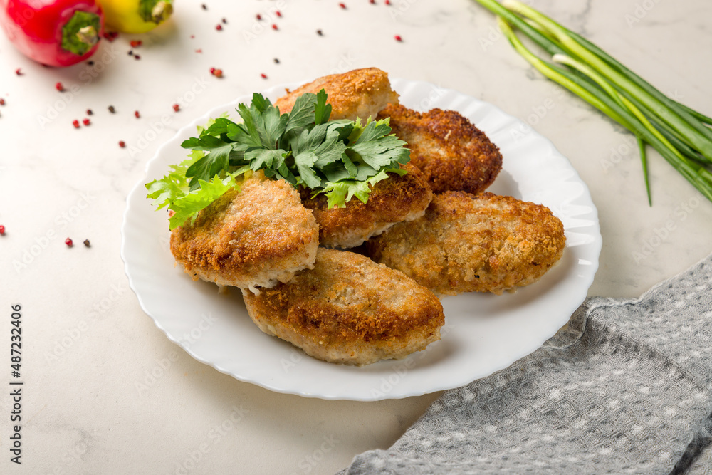 Chicken cutlets on plate on white marble table Chicken cutlets on plate on white marble table