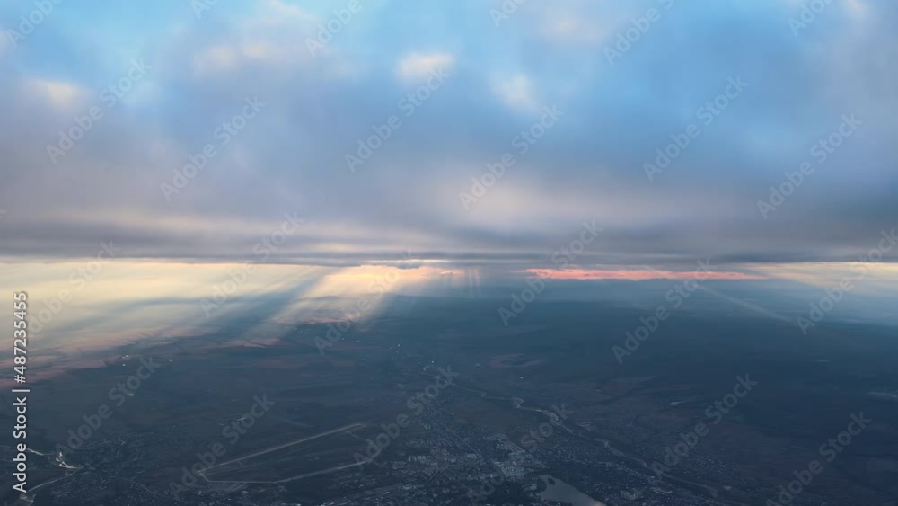 Aerial view from airplane window at high altitude of earth covered with white thin layer of misty haze and distant clouds Aerial view from airplane window at high altitude of earth covered with white thin layer of misty haze and distant clouds