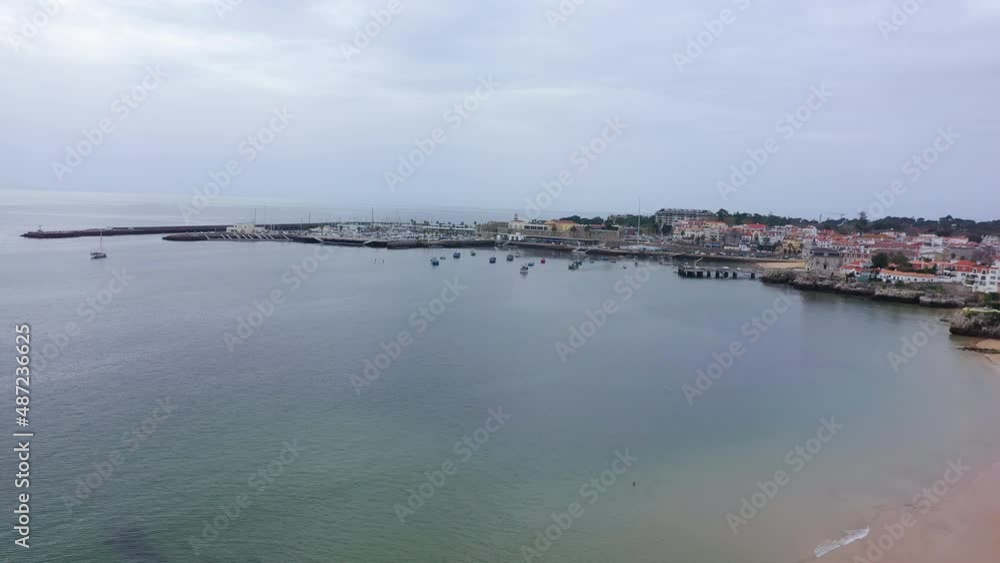 Aerial view of the coast of Cascais in cloudy Lisbon, Portugal - circling, drone shot Aerial view of the coast of Cascais in cloudy Lisbon, Portugal - circling, drone shot