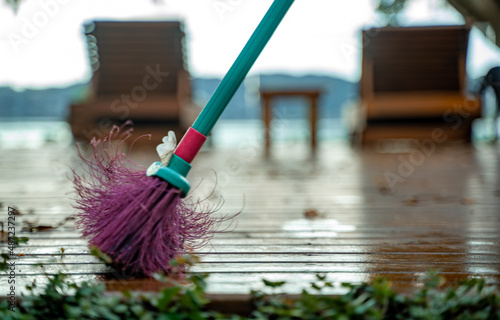 Wallpaper Mural woman sweeping leaves from the backyard of her house with a broom in the morning Torontodigital.ca