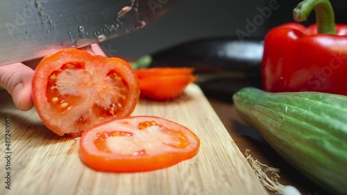 Chopping a tomato on a wooden board