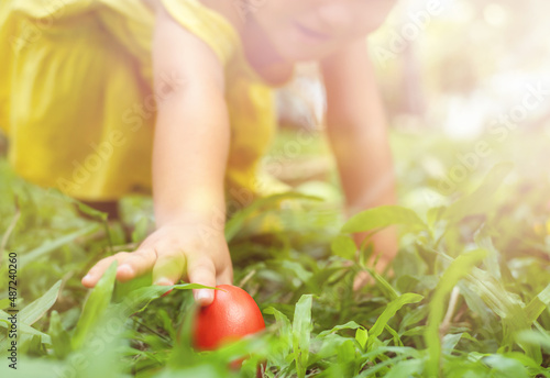 Canvas Print Child reaching for a red easter egg