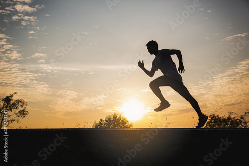 Fototapeta Naklejka Na Ścianę i Meble -  Young man running in the city. Healthy lifestyle concept. Young fitness man runner athlete running at park. Athlete runner feet running on road, Jogging concept at outdoors. Man running for exercise.