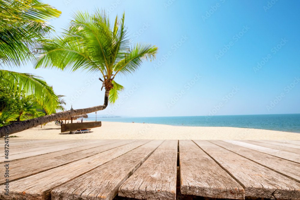 Top of wood table with seascape and palm tree, blur of calm sea and sky at tropical beach background. Empty ready for your product display montage. summer vacation background concept.