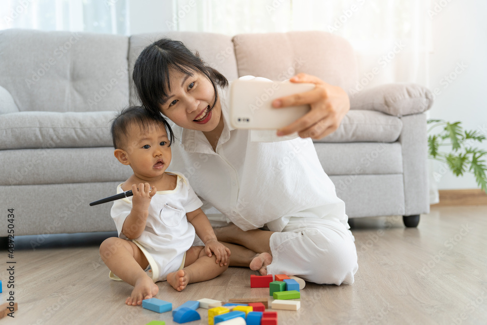 Happy single mom hugging daughter selfie together. Cute smiling daughter having fun taking pictures with lovely asian mother, warm relationship, mother and child. Happy single mom hugging daughter selfie together. Cute smiling daughter having fun taking pictures with lovely asian mother, warm relationship, mother and child.