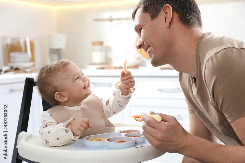 Father feeding his cute little baby healthy food at home Father feeding his cute little baby healthy food at home