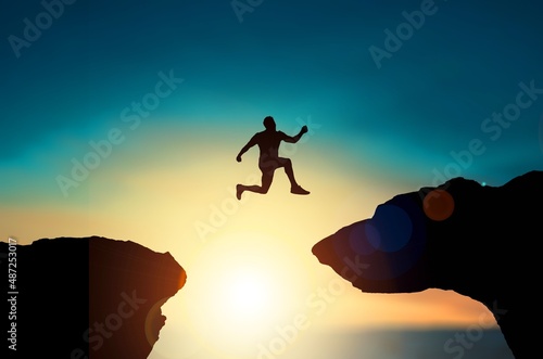 Canvas Print A silhouette man jump between 2021 and 2022 years with sunset background, Success new year concept