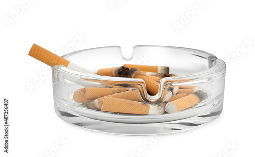 Glass ashtray with cigarette stubs isolated on white photo