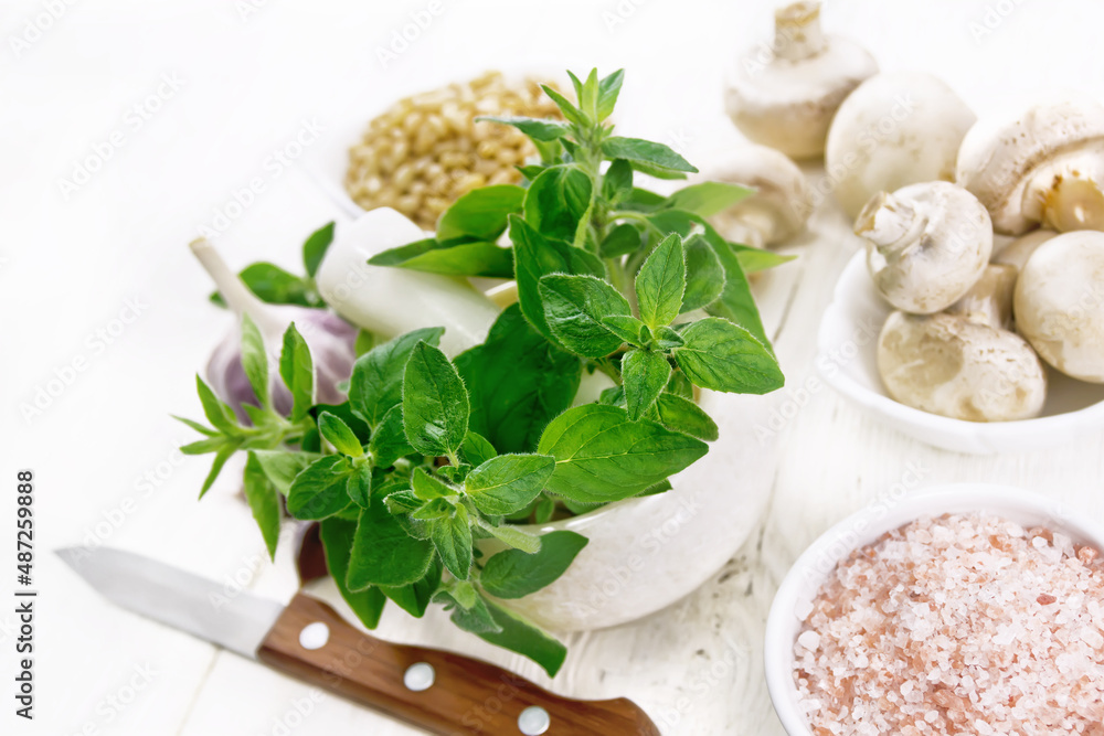Oregano fresh in mortar on wooden table Oregano fresh in mortar on wooden table