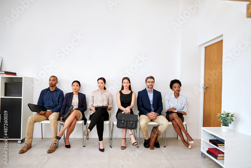 Its a long wait, but itll be worth it. Shot of a group of businesspeople seated in line while waiting to be interviewed.