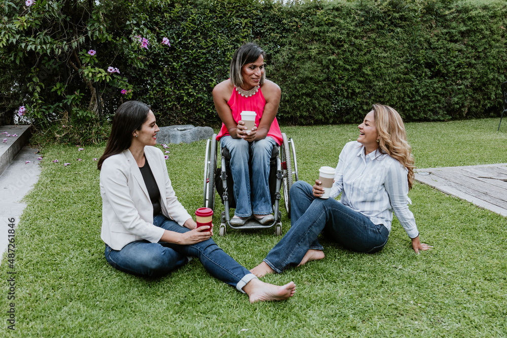 Latin business woman transgender on wheels chair and friends sitting on grass and meditating at terrace office in Mexico Latin America Latin business woman transgender on wheels chair and friends sitting on grass and meditating at terrace office in Mexico Latin America