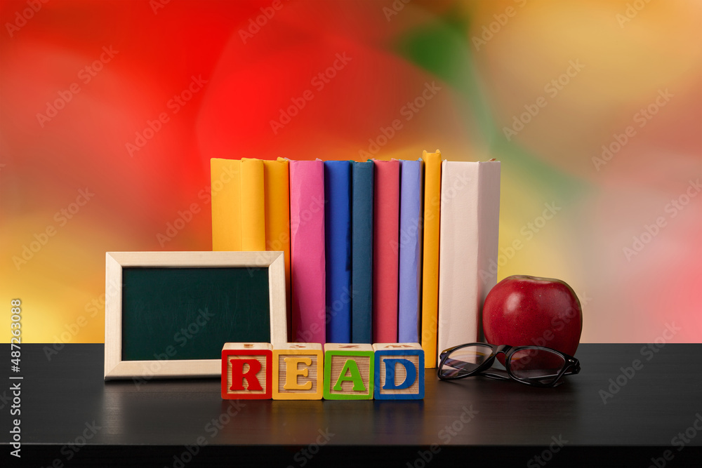 Stack of books on wooden table against blurred background Stack of books on wooden table against blurred background