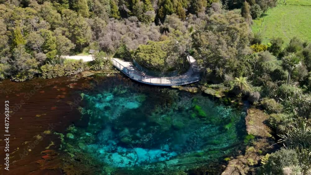 Photographer taking picture of beautiful natural colorful deep spring. Te Waikoropupu Springs, New Zealand - aerial drone Photographer taking picture of beautiful natural colorful deep spring. Te Waikoropupu Springs, New Zealand - aerial drone