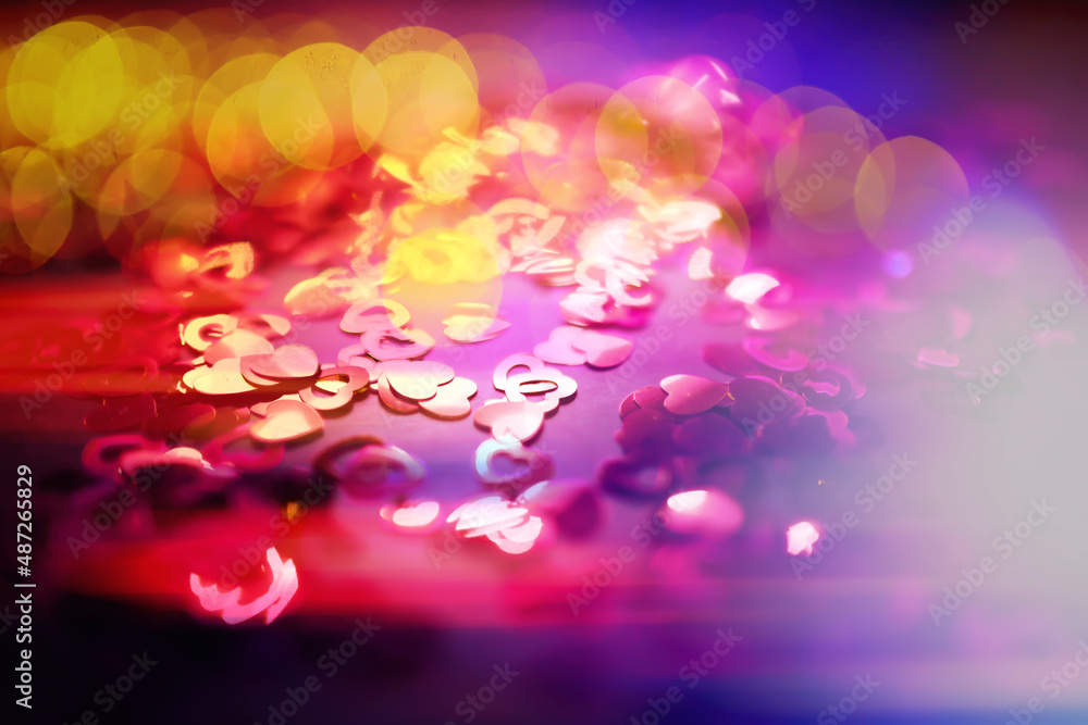 Abstract colored background. Red toy in the shape of a heart on a glitter and bokeh background. Abstract colored background. Red toy in the shape of a heart on a glitter and bokeh background.